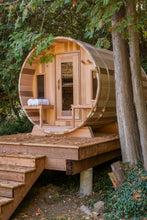 Load image into Gallery viewer, Dundalk Leisurecraft Canadian Timber Tranquility Barrel Sauna with Front Porch, placed outside near trees in a backyard facing left