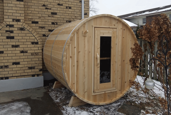 Dundalk Leisurecraft Canadian Timber Harmony Barrel Sauna outside facing right with snow on the ground