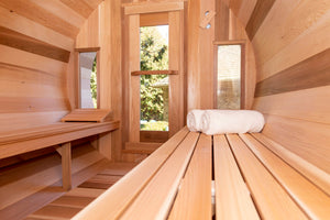 Inside the Dundalk Leisurecraft Tranquility Barrel Sauna looking outside from the window on the door, viewing towels and back rest